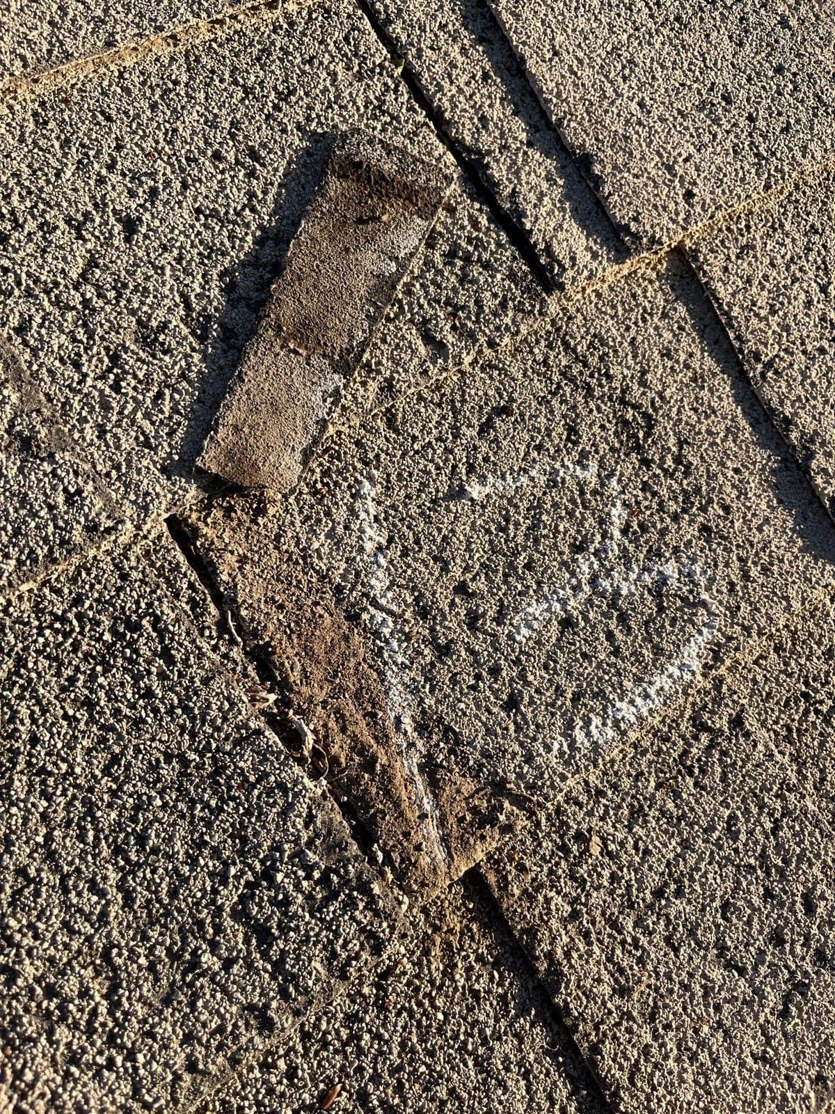 A torn shingle circled in chalk